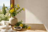 Flores amarillas de onagra y semillas sobre una mesa de madera clara