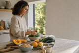 Mujer preparando alimentos saludables de otoño en una cocina luminosa