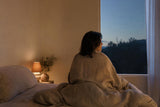 Persona despierta de madrugada en un dormitorio tranquilo con luz tenue.