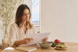 Mujer revisando una analítica junto a alimentos ricos en hierro y vitamina C.